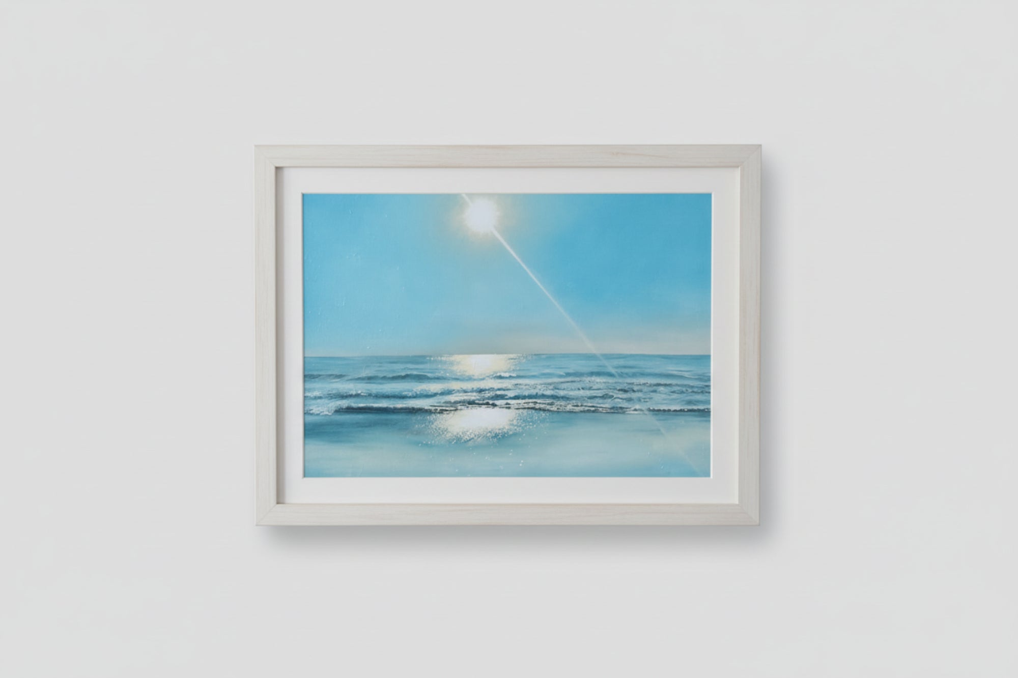 Framed artwork of a beach scene with a blue sky and sun.
